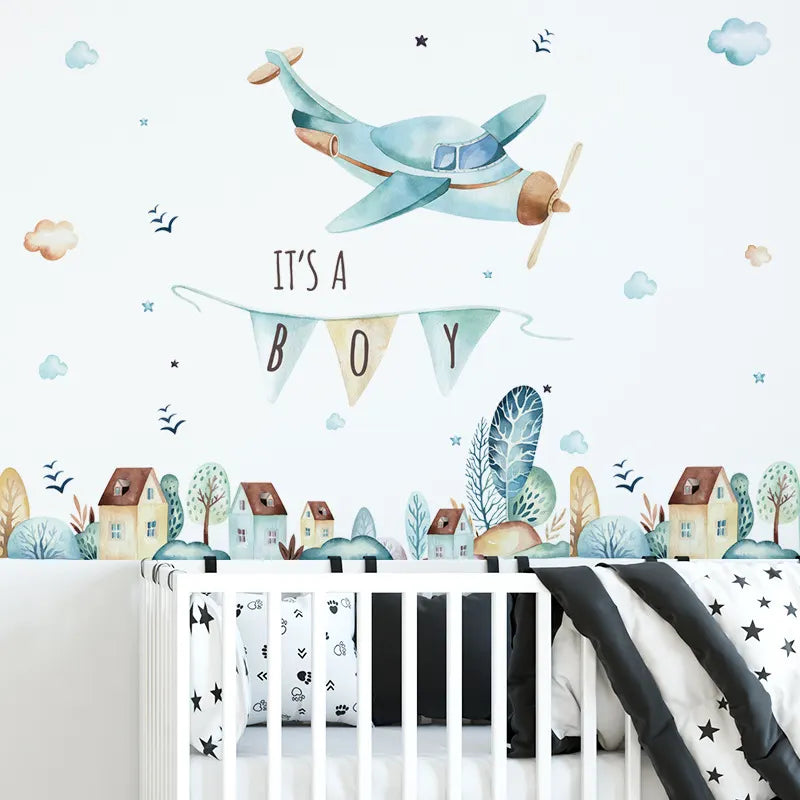 Nursery room with airplane wall decal, 'It's a Boy' banner, and crib.