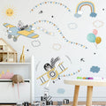 Children's room with airplane and zebra wall decals, balloons, and a toy house.