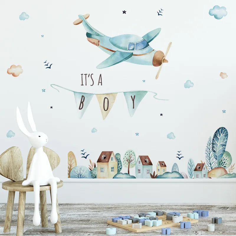 Children's room with airplane wall decal, 'It's a Boy' banner, and rabbit figurine.