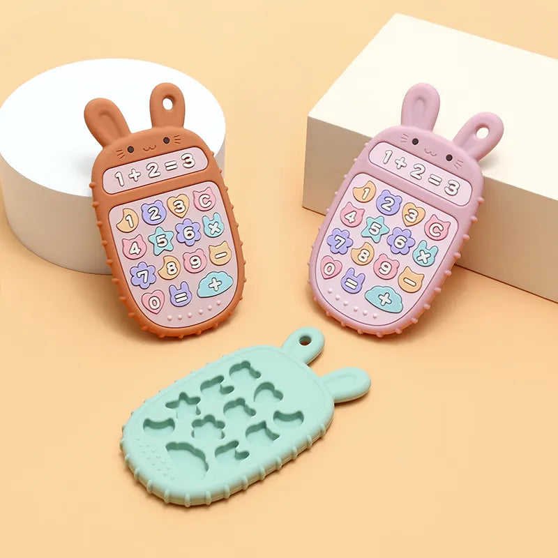 Three Tipi Tipi Tap bunny calculator teether toys on a beige background
