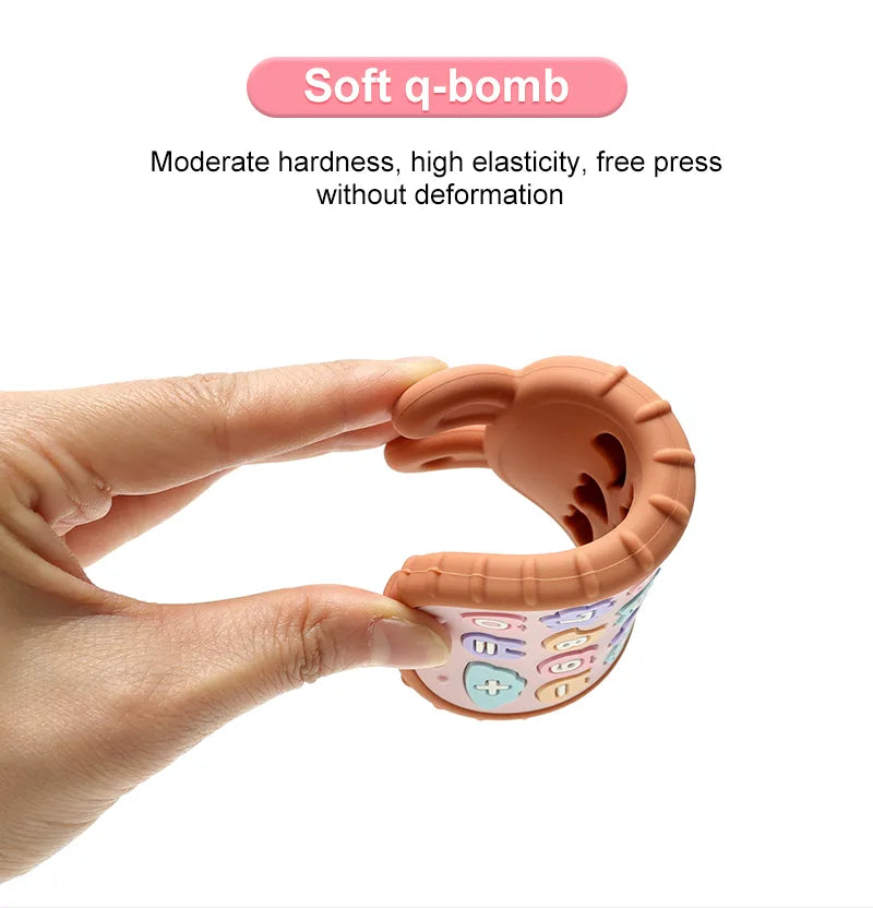 Hand holding a soft Tipi Tipi Tap silicone bunny calculator teether toy with text informing about elasticity on a white background