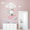 Tipi Tipi Tap Cute Bunny Swing On Cloud wall decal on a pink wall above a white dresser.