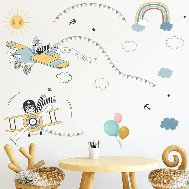 Children's room with airplane wall decals, balloons, and a small table.