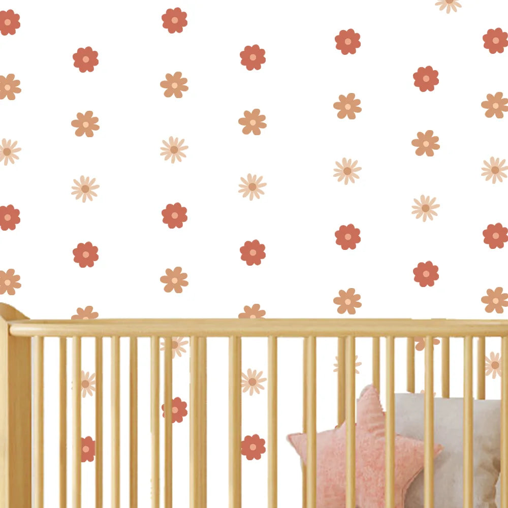 Crib with pink and orange floral wall decals on a white wall