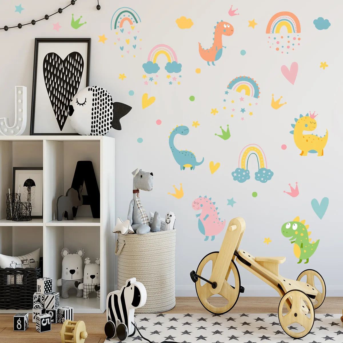 Children's room with Tipi Tipi Tap dinosaur and rainbow wall decals, wooden tricycle, and toys on a shelf.