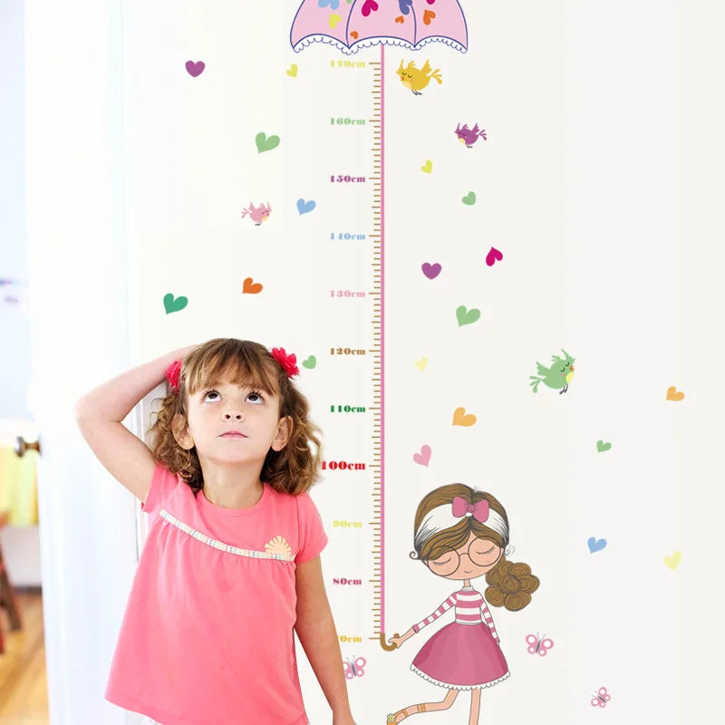 Child measuring their height against a decorative Tipi Tipi Tap Girl's Umbrella Height Chart wall decal with colorful elements.