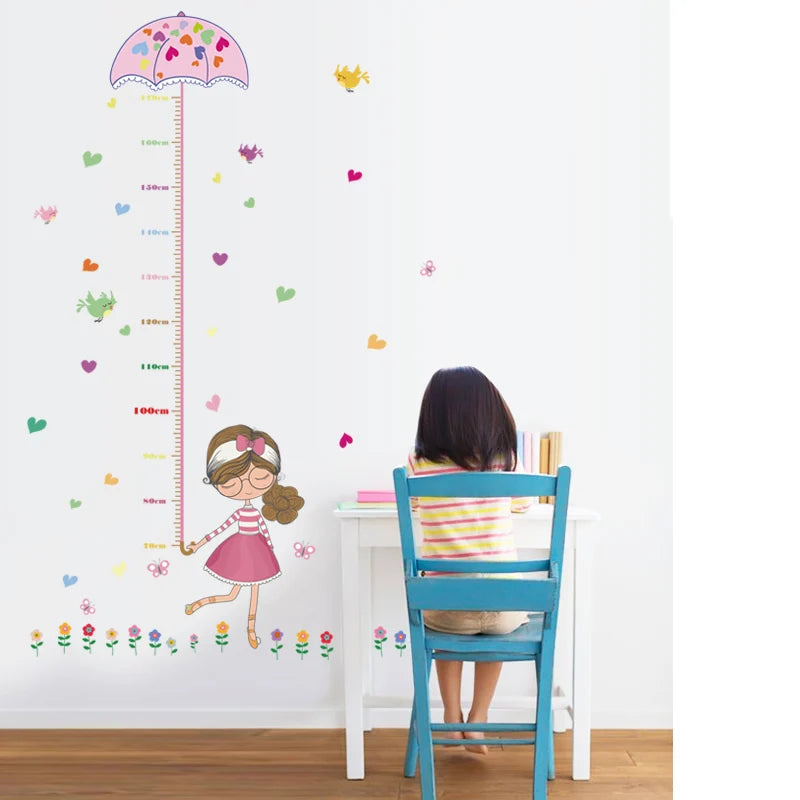 Child sitting at a table with a Tipi Tipi Tap Girl's Umbrella Height Chart wall  decal featuring a girl with an umbrella design.