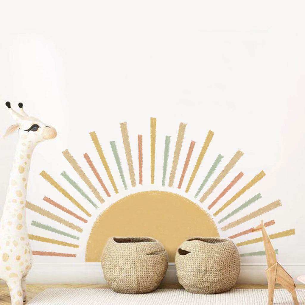Tipi Tipi Tap Sunburst Half Sun wall decal and two woven baskets and giraffe toys on a white wall.