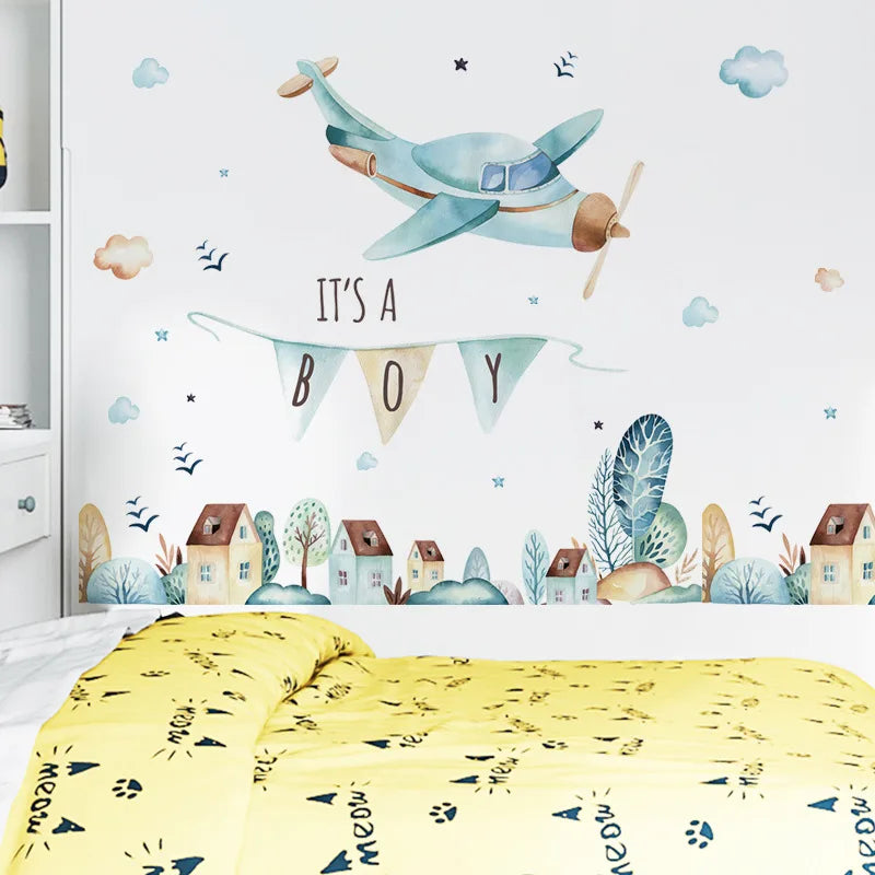 Children's room with a decorative wall mural featuring an airplane and 'It's a Boy' banner.