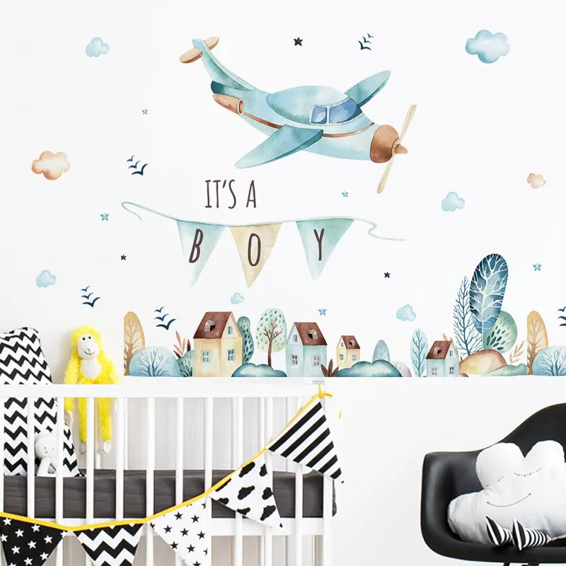 Nursery room with airplane wall decal, 'It's a Boy' banner, and crib.