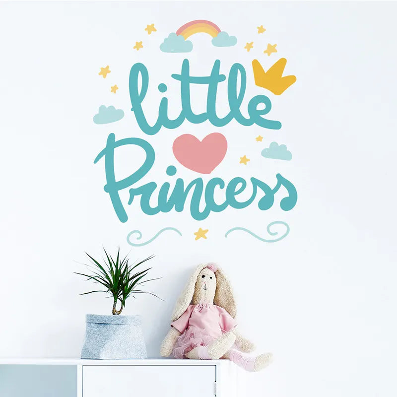 Tipi Tipi Tap Little Princess Crown and Heart  wall decal with 'little princess' text, heart, rainbow, and crown on a light blue background and a doll in a room.