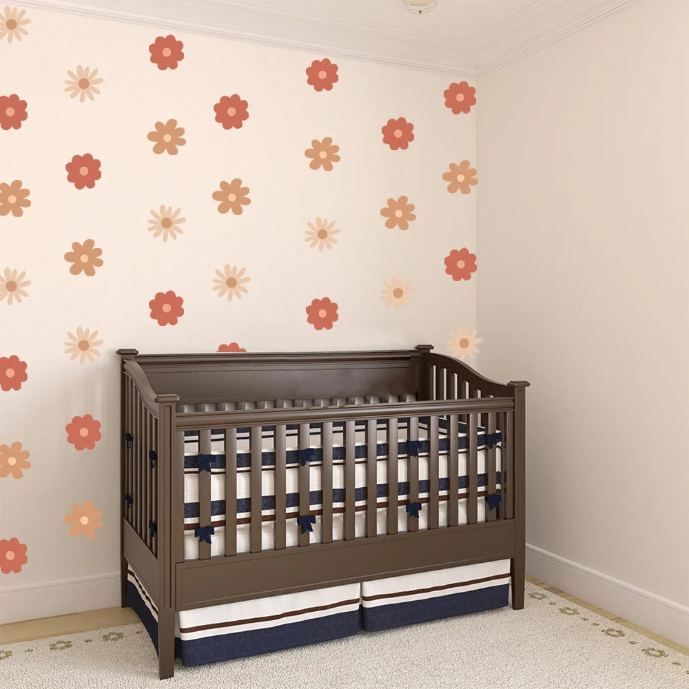 Wooden crib with striped bedding in a room with floral-patterned wallpaper.