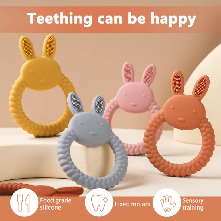 Four colorful Tipi Tipi Tap Rabbit Silicone Baby teethers on a beige background with text 'Teething can be happy'.