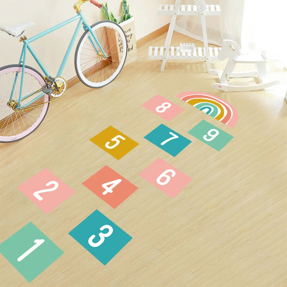 Colorful hopscotch grid on a wooden floor with a bicycle in the background.