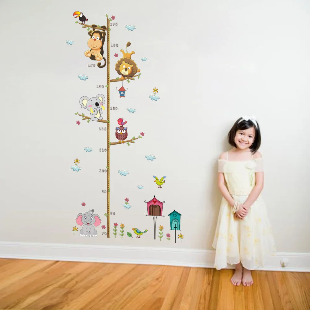 Child standing next to a height chart with animal illustrations on a white wall.