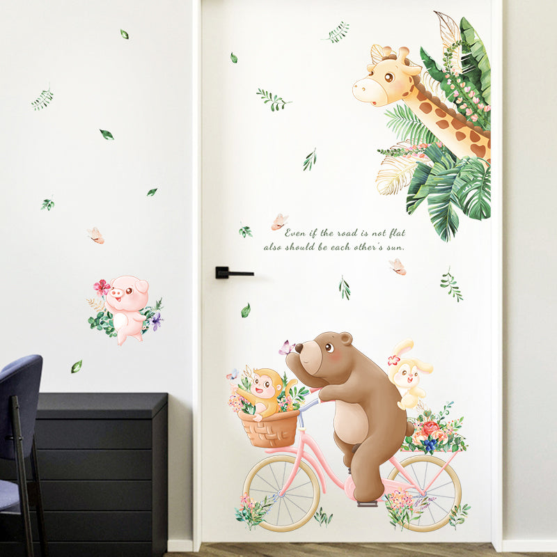 Wall decal of a bear on a bicycle with flowers, surrounded by other animal illustrations on a white wall.