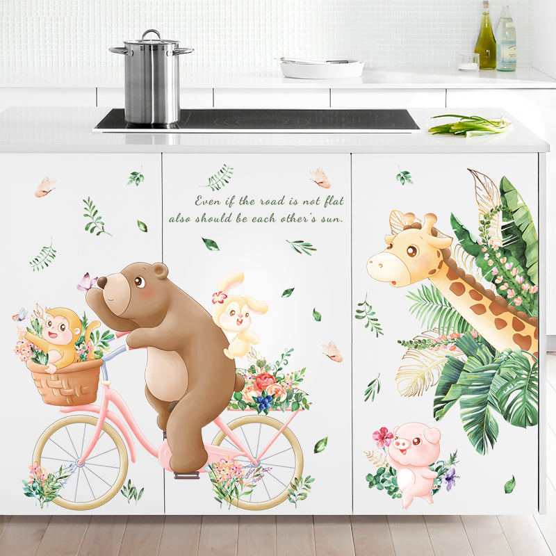 Kitchen cabinets with animal-themed decorative stickers, including a bear on a bicycle and a giraffe.