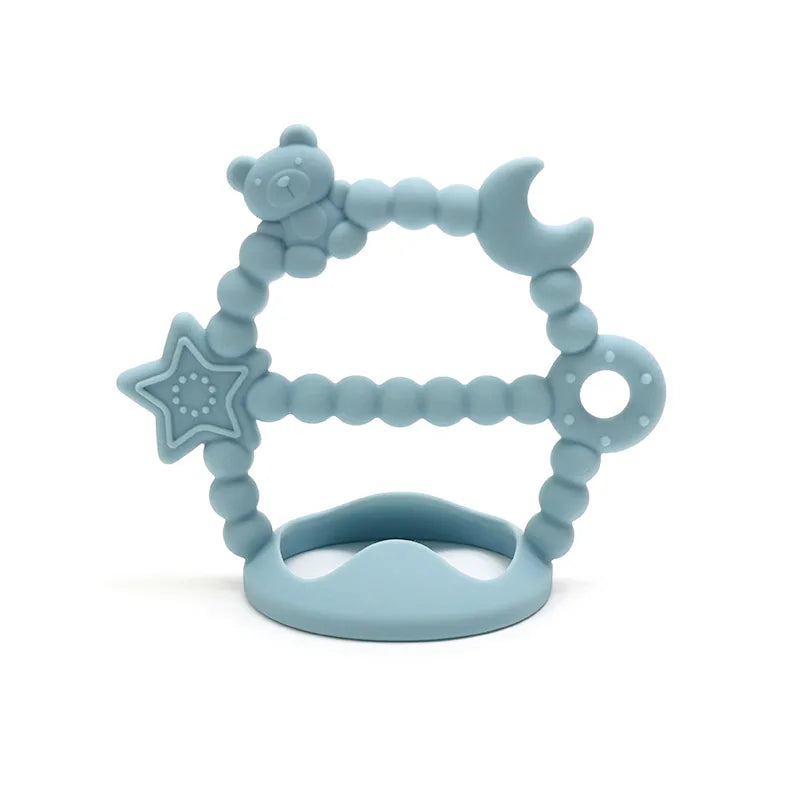 Blue Tipi Tipi Tap silicone wrist teether with star, moon, and bear designs on a white background.