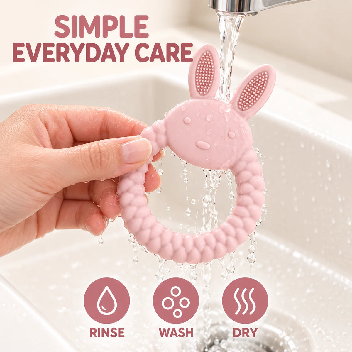 A pink Tipi Tipi Tap Rabbit Silicone Baby Teether being held by a hand under running water in a sink, with the text 'SIMPLE EVERYDAY CARE' and three icons for rinse, wash, and dry.