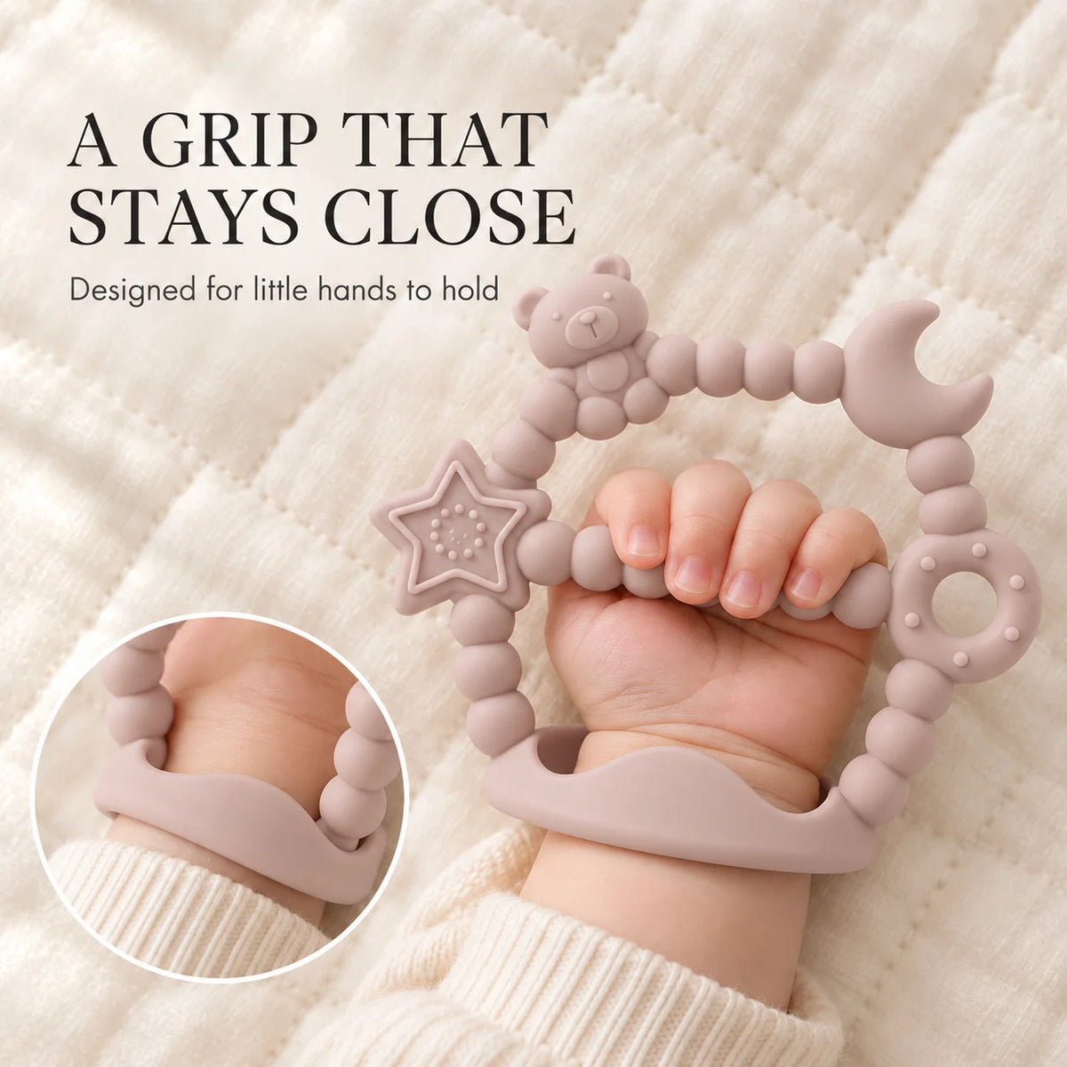 A baby's hand grips a dusty pink Tipi Tipi Tap Silicone Baby Wrist Teether (Moon & Star) with beads, a bear, a star, a moon, and a donut, resting on a cream quilted blanket. Text on the left reads 'A GRIP THAT STAYS CLOSE' and 'Designed for little hands to hold', with a circular inset showing the product on a wrist.
