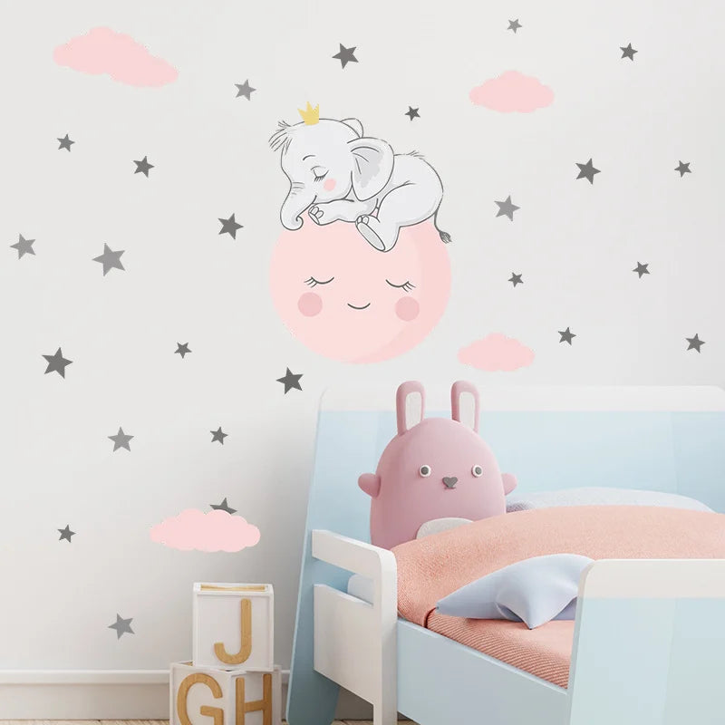 Children's room with a bed, pink pillow, and wall decal of an elephant and moon.