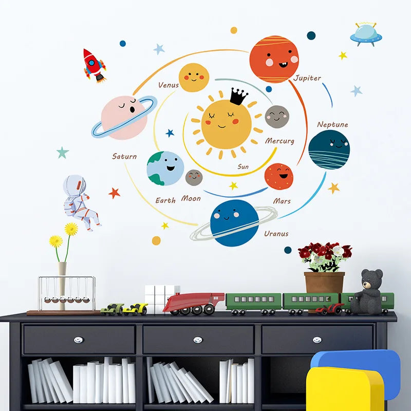 Children's room with Tipi Tipi Tap Smiling Solar System wall sticker, toys, and books on a desk.