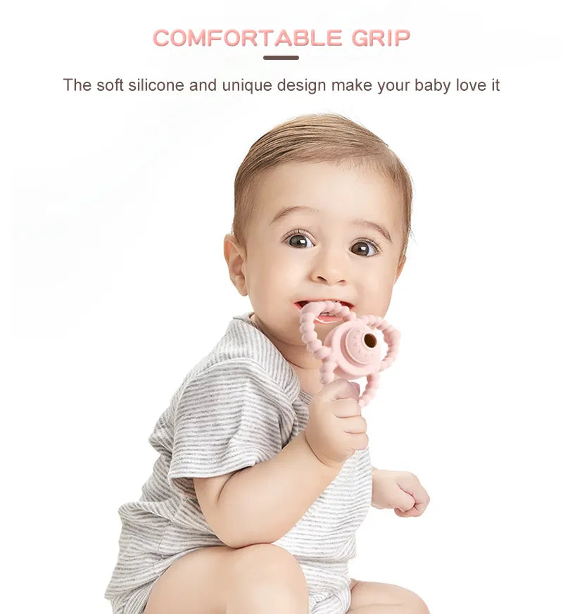 Baby holding a pink Tipi Tipi Tap Triangular Rattle Teether toy with text about comfortable grip and soft silicone design.