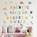 Children's room with Pumkins colorful alphabet and dinosaur wall decals on a light gray wall.